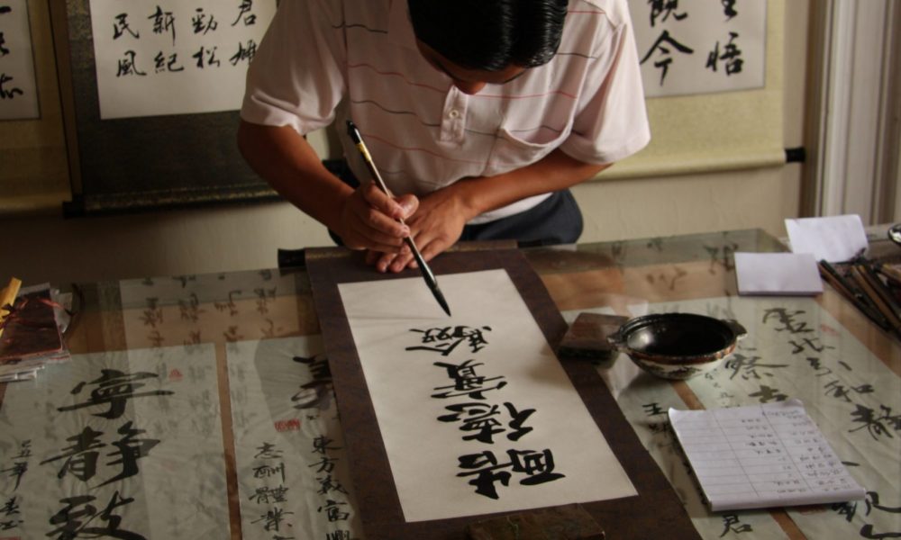 Calligrapher writing with a dip pen - calligraphy vs hand lettering